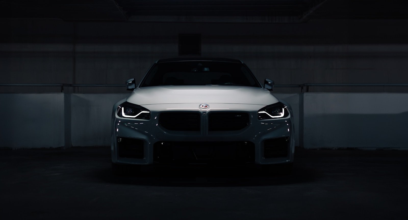 A white car parked in a parking garage